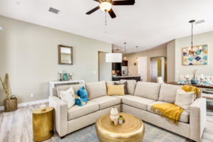 view of a living room decorated in beige with yellow, gold, and blue accents in a home by Cullers Homes