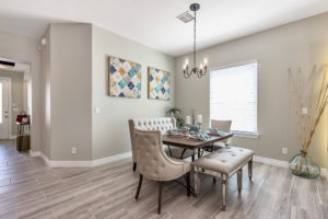 view of a dining area decorated in grays with beautiful antiqued wood floors that is an example of custom builder Cullers Homes