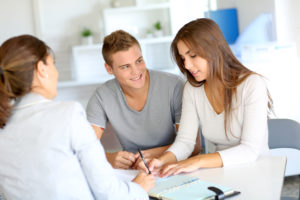 young couple meeting with a banker before buying a new home