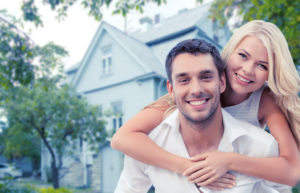 happy couple hugging in front of a few new homes