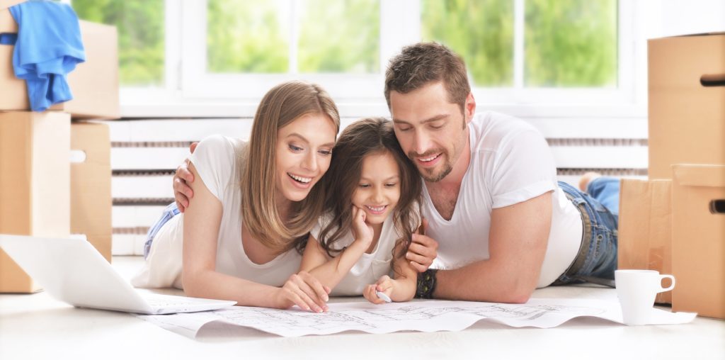 a happy young family looking up new homes for sale