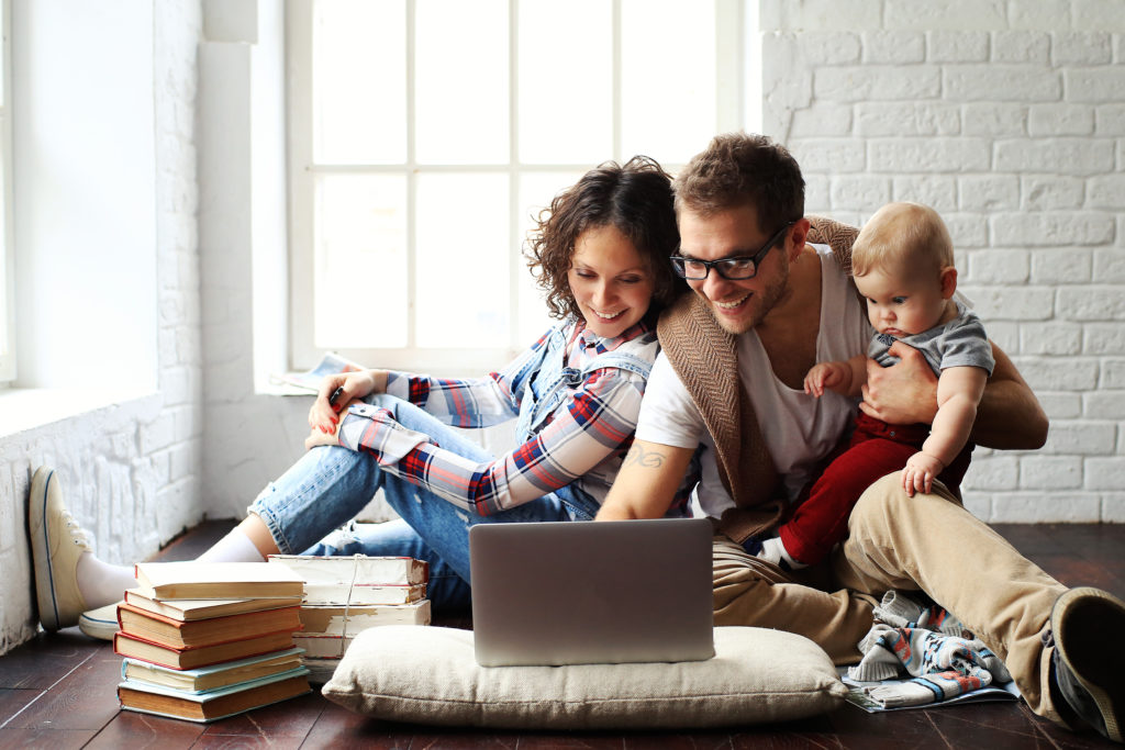 young couple using a computer to look for new homes for sale