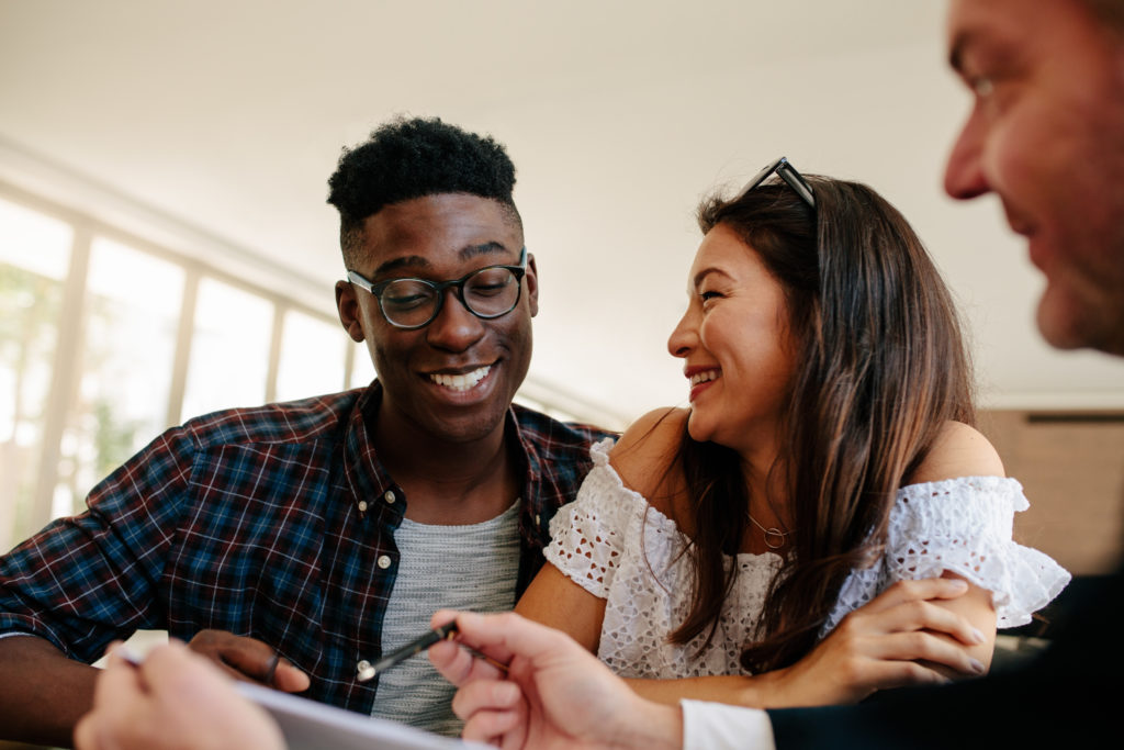 young couple signing their new home's paperwork